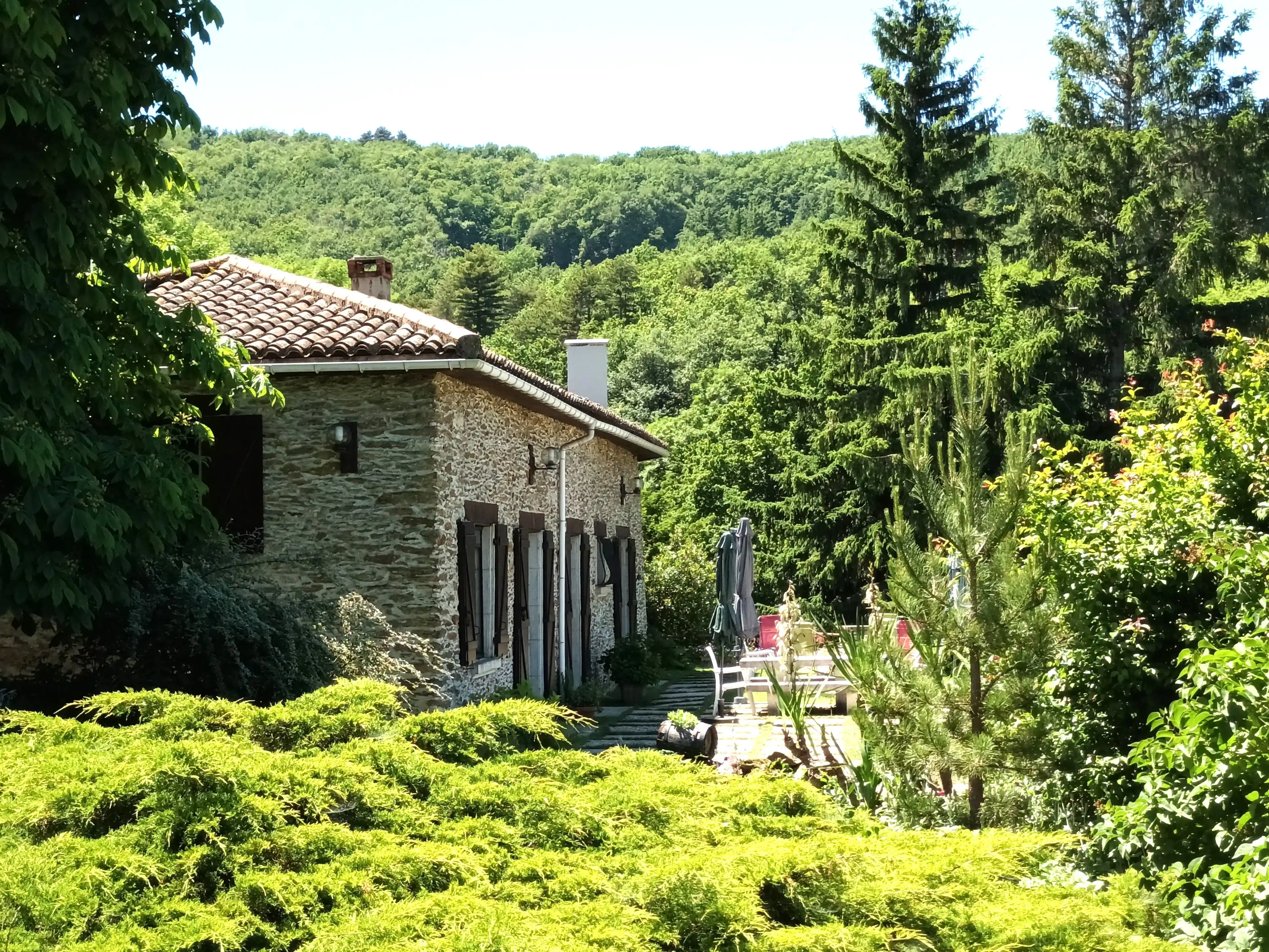 Terrasse en pierre du gîte avec vue panoramique sur les monts du Pilat